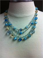 4 strands of varigated blue beads, crystals and charms